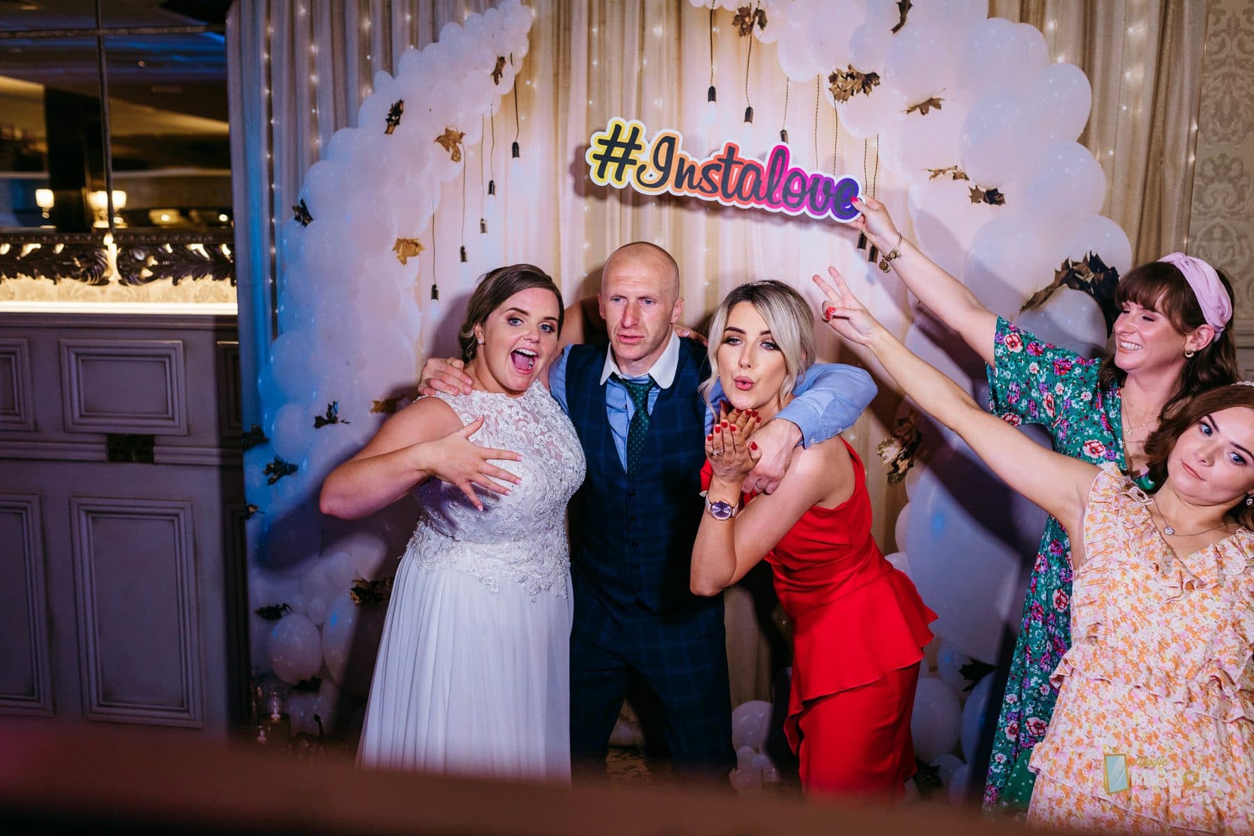Wedding party celebrating in front of the mirror photo booth at a New York City reception